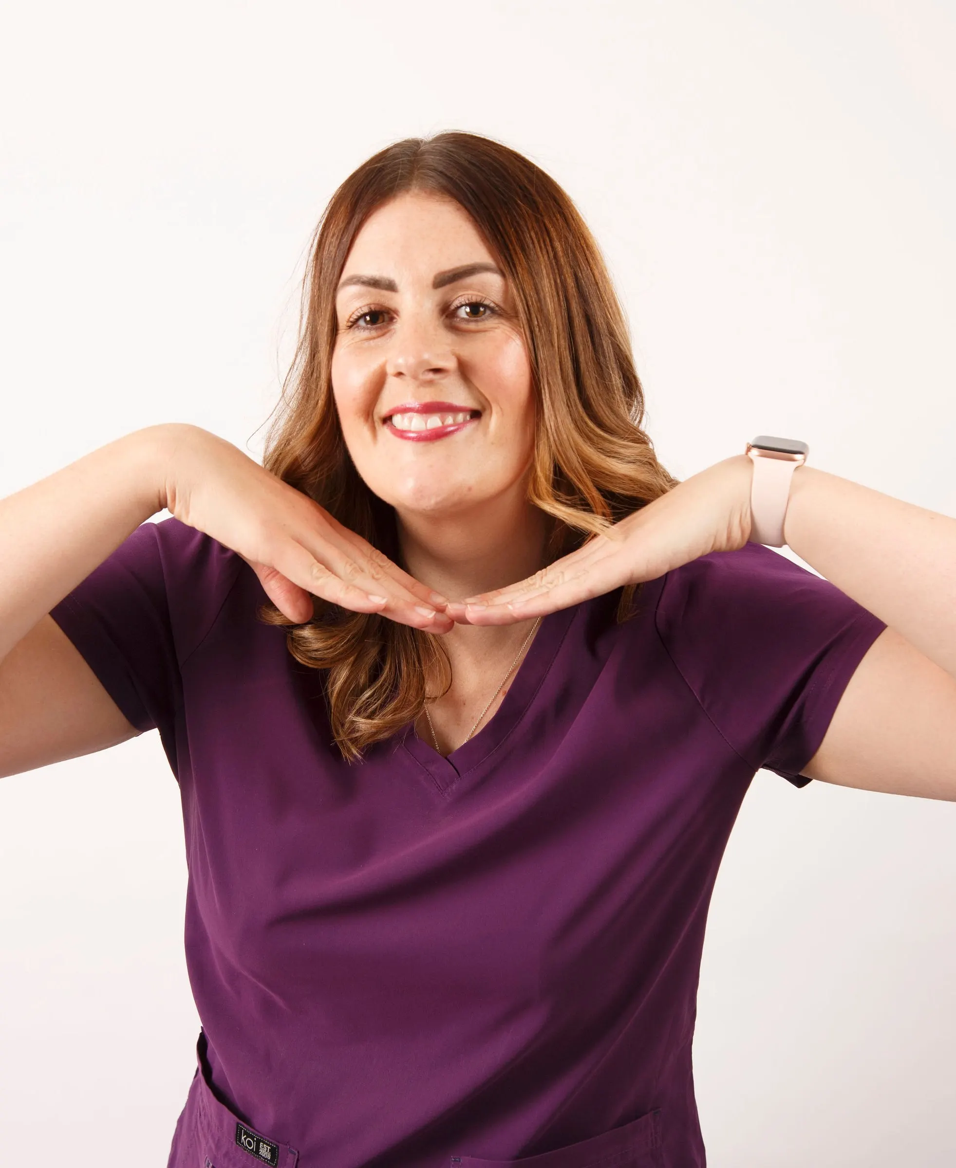 Gemma Whitehurst, orthodontic therapist, framing her smile with her hands
