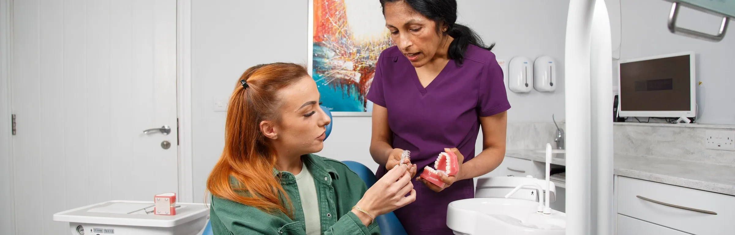 Dr Anjli Patel showing a patient a model of teeth