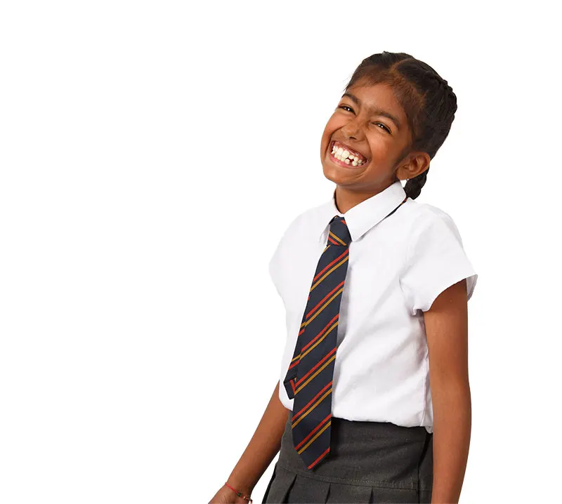 A boy in school uniform laughing with a clear aligner in his hand